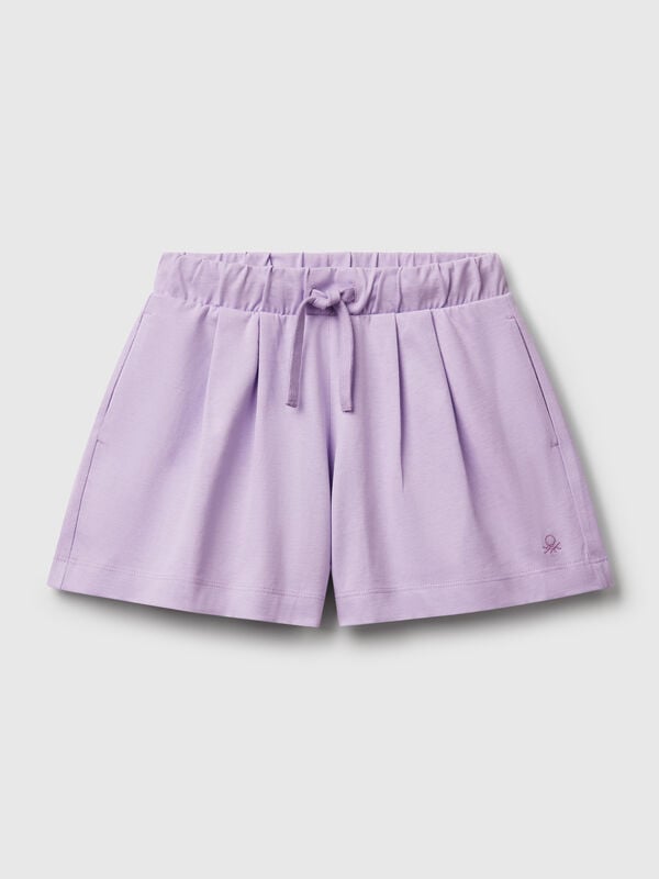 Pantalón corto de puro algodón de tacto cálido. Cintura con cordón, bolsillos insertados en los laterales y logo bordado en el bajo izquierdo. Perfecto para outfits cotidianos. Niña