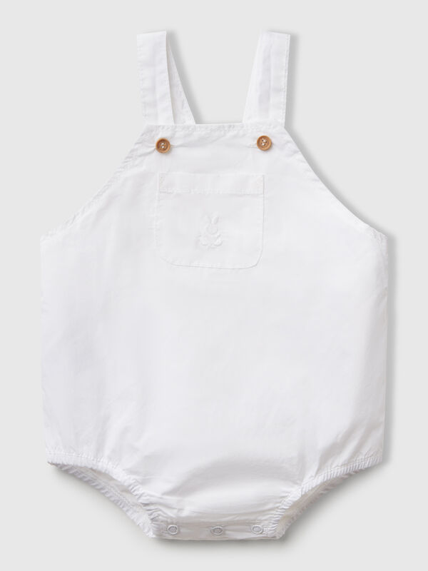 Peto de puro algodón. Tirantes ajustables con botones efecto madera, bolsillo de parche en la parte delantera y elástico interno en la pierna. Apertura con botones a presión en la entrepierna. Perfecto con una camiseta colorida. Recién nacidos