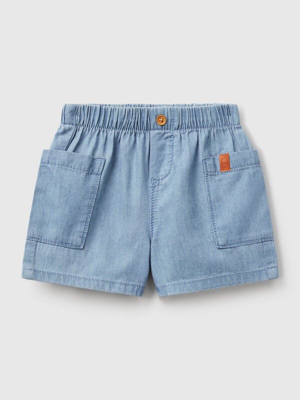 Pantalón corto de cambray de puro algodón. Cintura con elástico interno y falsa solapa con botón efecto madera. Grandes bolsillos aplicados lateralmente. Cómodo y versátil, también se puede combinar con una camisa. Recién nacidos